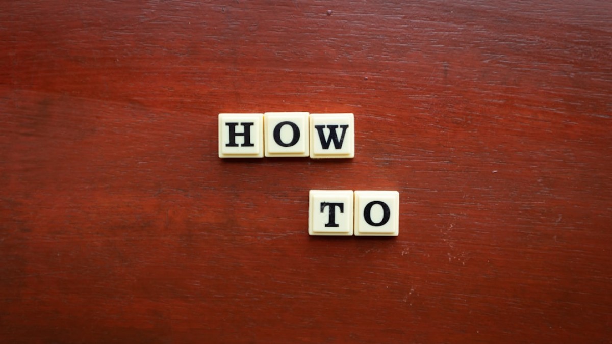 the word how to spelled with scrabble tiles on a wooden surface