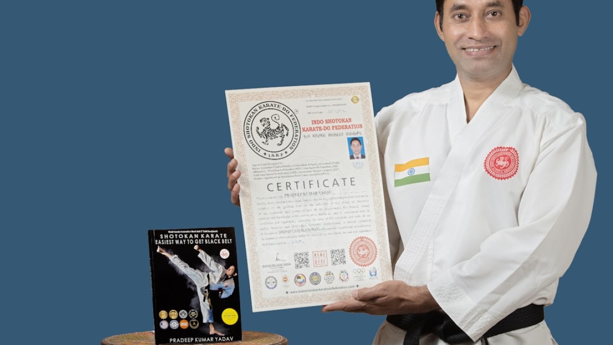 a man holding up a certificate next to a table