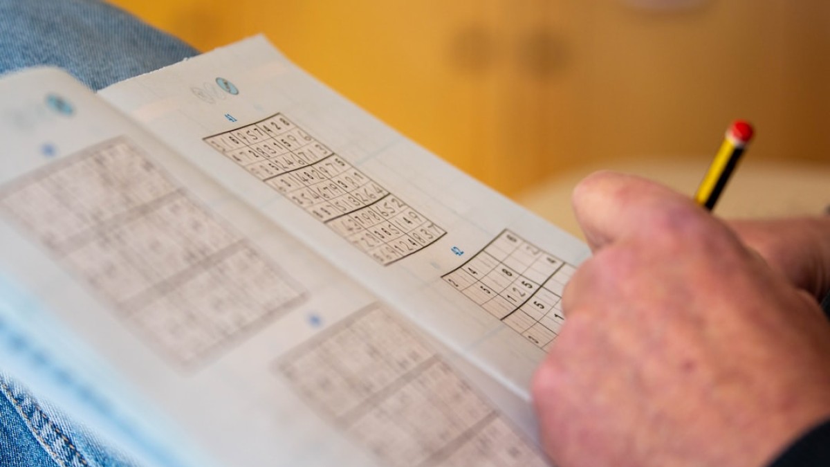 a person is holding a piece of paper with numbers on it