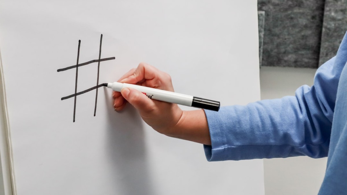 a person writing on a piece of paper with a marker