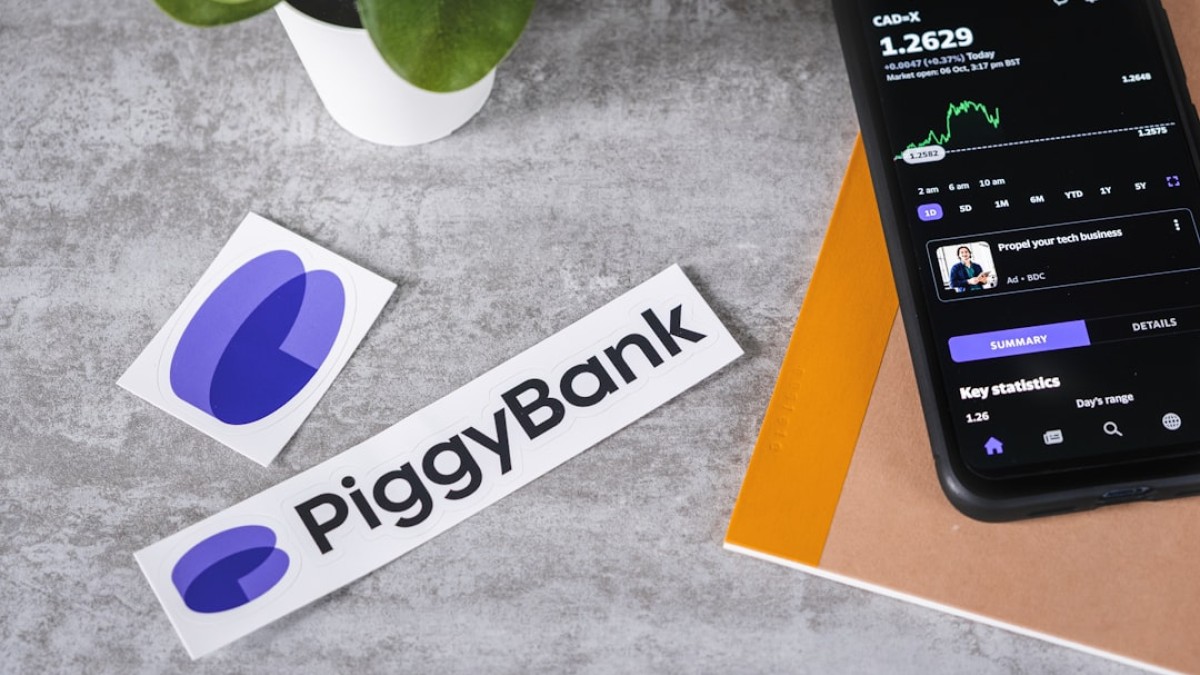 a cell phone sitting next to a piggy bank sticker