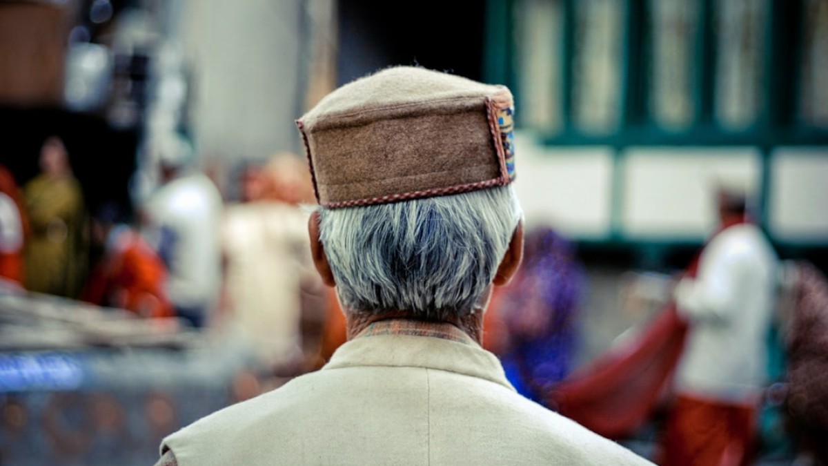 a man with a hat on his head walking down a street