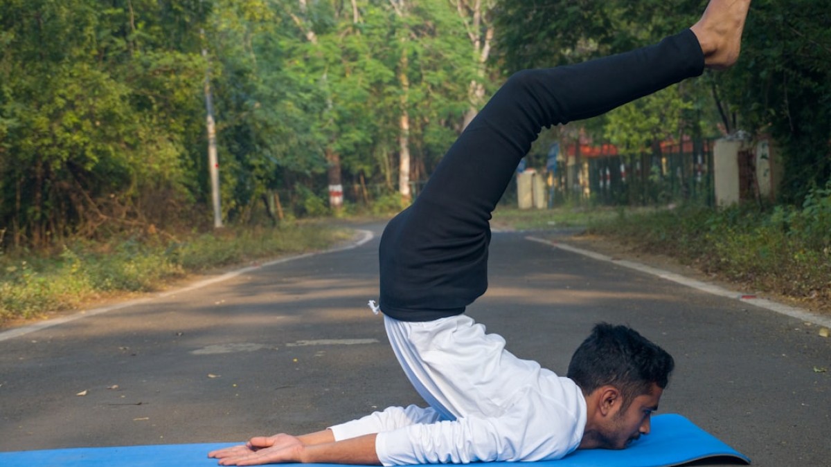 A man doing a yoga pose on a blue mat