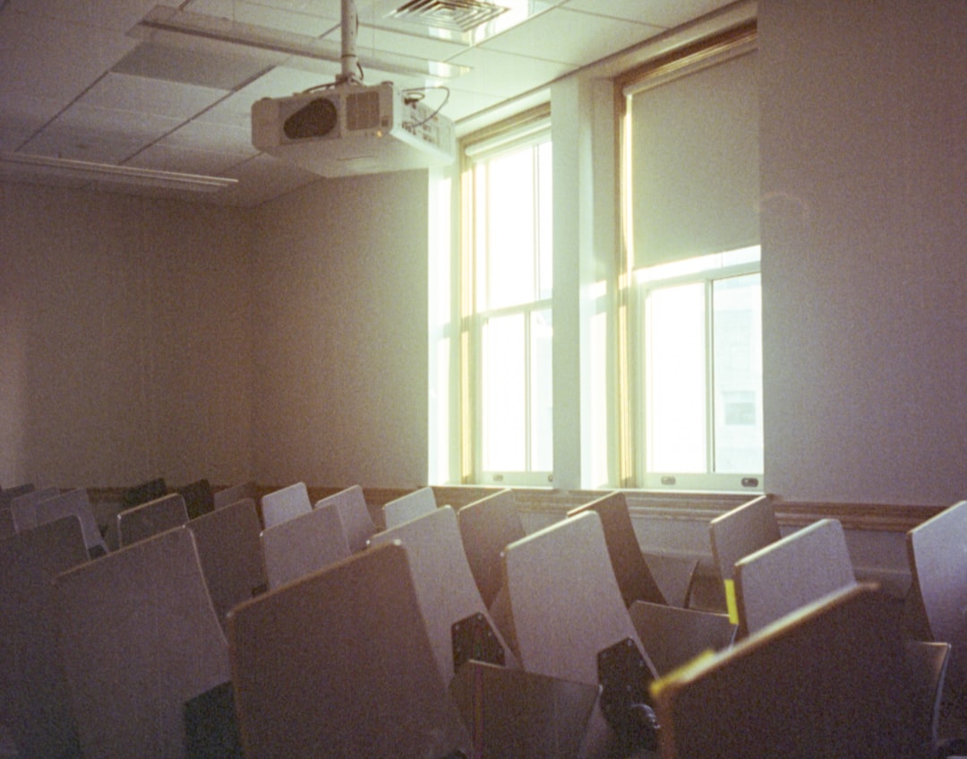 A room filled with lots of white chairs next to a window